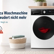 Eine Amica Waschmaschine mit roten Wäschestücken in der Trommel