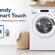 Candy Smart Touch Waschmaschine neben einem Korb mit Wäsche, daneben ein Smartphone mit Bluetooth-Symbol und einem roten X